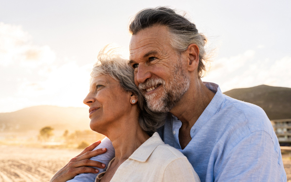 iStock image of an older couple holding each other and smiling into the distance | Icon Cancer Centre