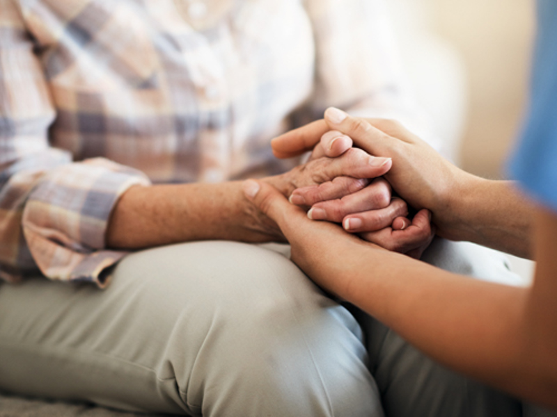 iStock image of a nurse holding a patient's hands for comfort | Icon Cancer Centre